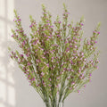 Pack of 6 x 100cm Artificial Foliage Stem with Small Flowers - Purple styled in a room