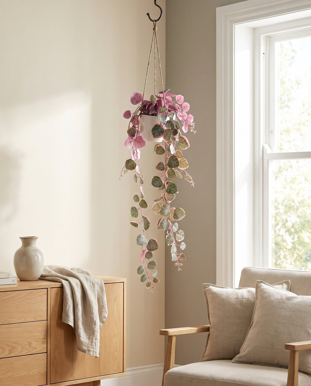 90cm Artificial Potted Hanging Trailing Pink Plant - String of Hearts styled in a room