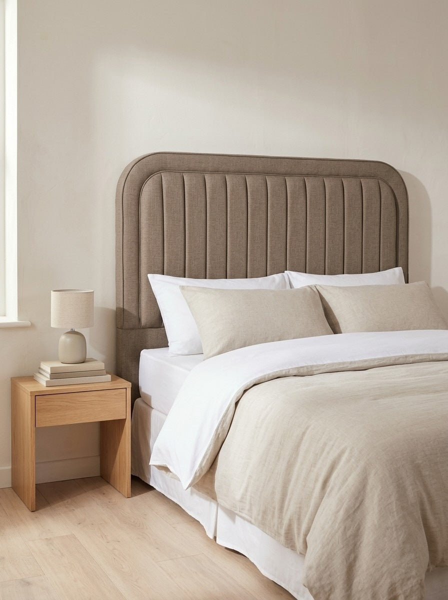 Sapphire headboard in Linoso Sand fabric on a made-up bed