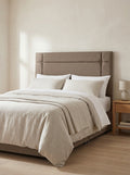 Colton headboard in Linoso Sand fabric on a made-up bed