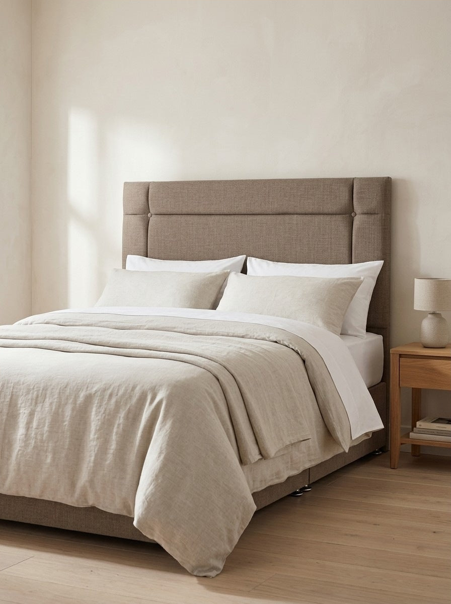 Colton headboard in Linoso Sand fabric on a made-up bed