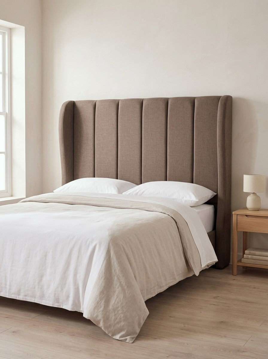 Macie headboard in Linoso Sand fabric on a made-up bed