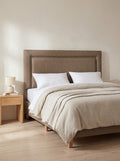 York headboard in Linoso Sand fabric on a made-up bed