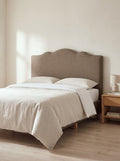 Ashby headboard in Linoso Sand fabric on a made-up bed