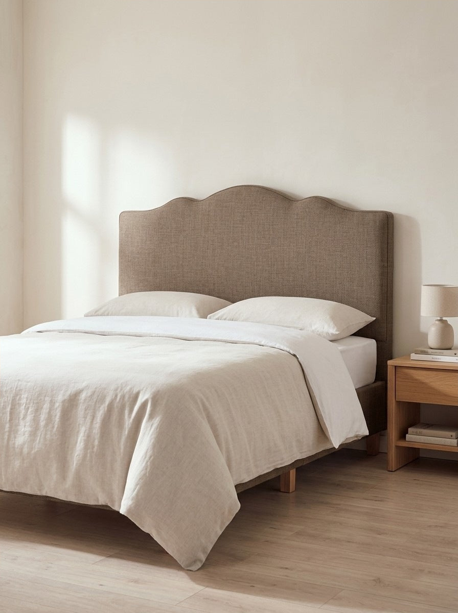 Ashby headboard in Linoso Sand fabric on a made-up bed